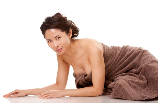 beautiful asian brunette wearing brown towel on white background