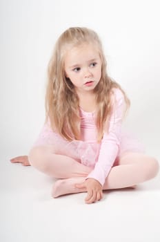 Studio shot of ballet dancer girl sitting on the floor