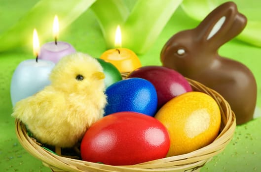 Colourful arrangement of chicks,Easter eggs,chocolate bunny and candles
