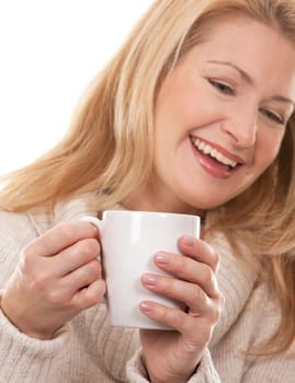 pretty blond woman wearing beige sweather drinking coffee