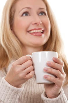 pretty blond woman wearing beige sweather drinking coffee