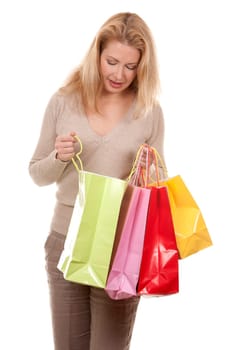 pretty blond woman wearing beige sweather holding shopping bags