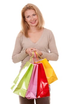 pretty blond woman wearing beige sweather holding shopping bags