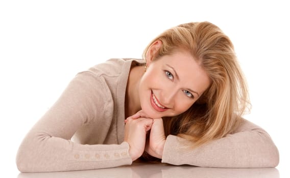 pretty blond woman wearing beige top sitting on white background