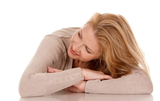 pretty blond woman wearing beige top sitting on white background