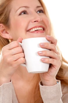 pretty blond woman wearing beige sweather drinking coffee
