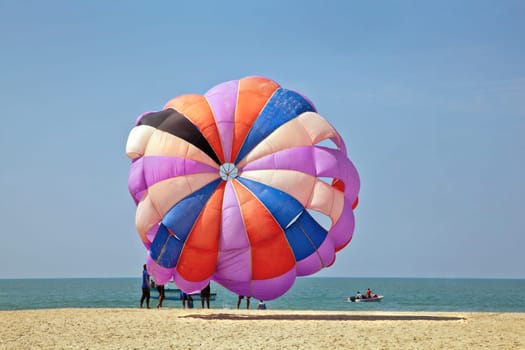 Horizontal generic seaside colorful coastal ocean landscape, tropical scene of paragliders about to take flight over the ocean and beach area of Uttorda Goa India