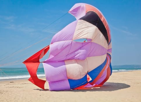 A cropped image from a landscape taken on Uttorda Beach, Goa, India, a popular holiday destination of a parachute being made ready for parasailing