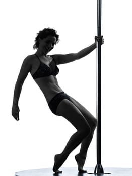 one caucasian woman pole dancer dancing in silhouette studio isolated on white background