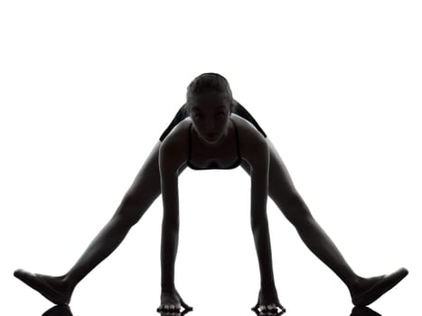 one caucasian young woman ballerina ballet dancer stretching warming up in silhouette studio on white background