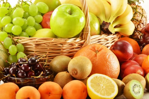 Composition with assorted fruits in wicker basket isolated on white