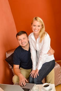 Happy couple using laptop computer sitting together coffee