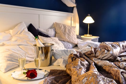 Romantic bedroom rumpled covers luxury hotel champagne bucket