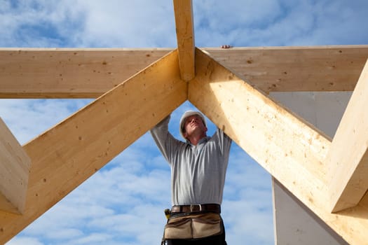 carpenter at work with wooden  roof construction