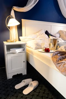 Romantic empty bed intimate moment slippers champagne hotel room