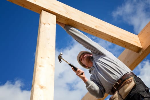 carpenter at work with wooden  roof construction
