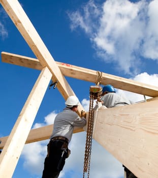 construction workers making a wooden  roof construction