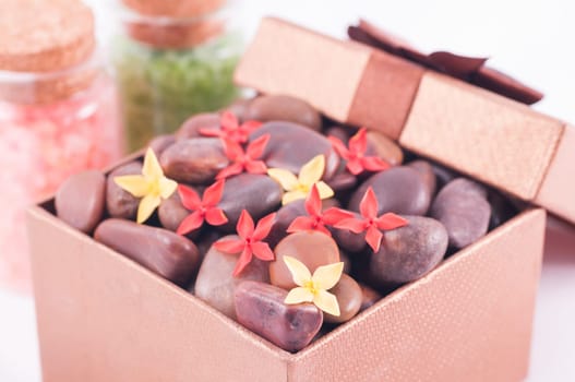 Spa concept - a gift of wellness with red zen stones and flowers