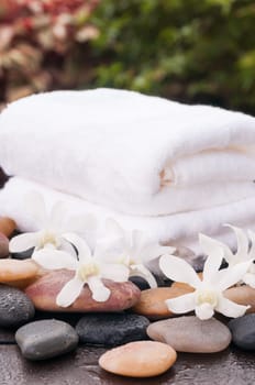 Spa concept with white orchids and zen stones outdoor