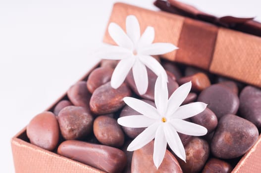 Spa concept - a gift of wellness with red zen stones and white jasmine flowers