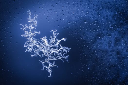 blue toned ice crystals forming on wet glass