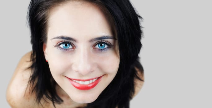 High angle view portrait of young brunette, cropped, isolated on grey.