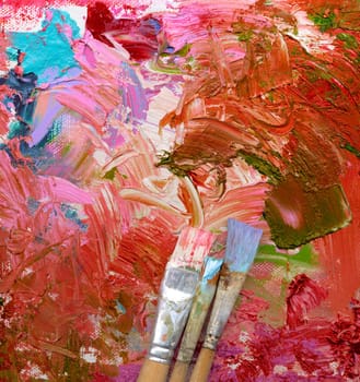 Different brushes with paint on painted background