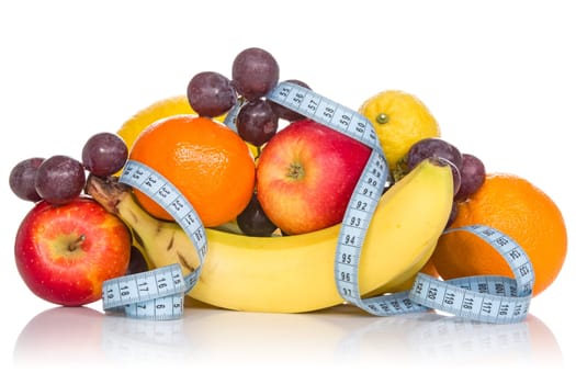 Pile of fruits with measure tape. Isolated on white background