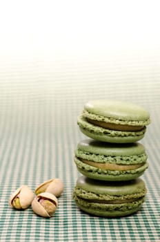 Three green macarons with three pistachios