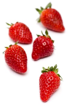 Five red strawberries on a white background in portrait format