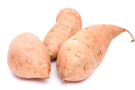 Raw sweet potatoes on a white background