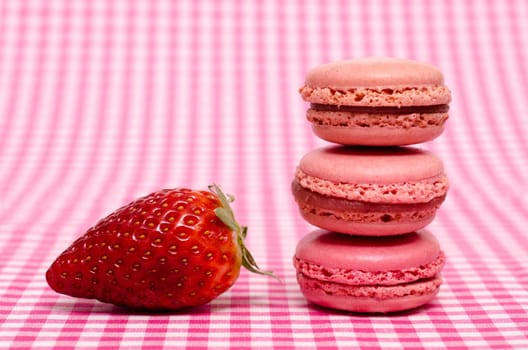Strawberry and three macarons in red color