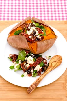 Baked sweet potato with stuffing of dried tomatoes,olives and feta