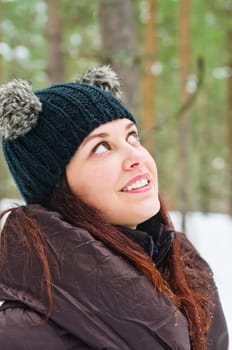 Portrait of the charming young woman in winter outdoors