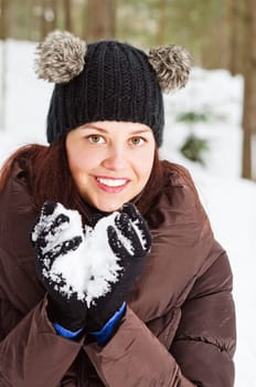 Cute young woman playing with snow  outdoors