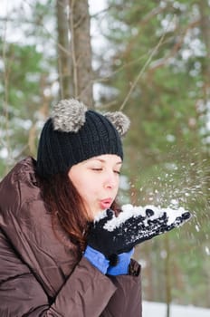 Cute young woman playing with snow  outdoors