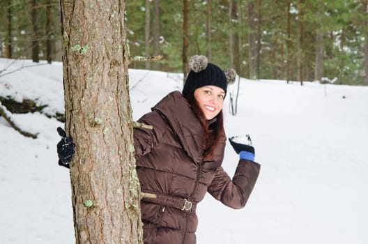 Cute young woman playing with snow  outdoors