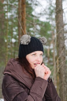 The young woman heats the frozen hands in winter park