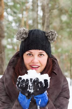 Cute young woman playing with snow  outdoors