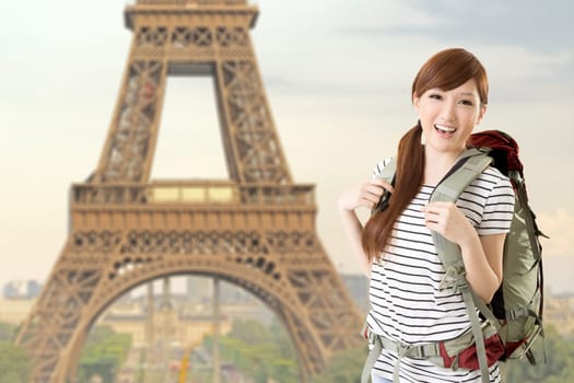 Happy smiling Asian woman travel and look at you in front of famous landmark, Eiffel tower in Paris, France.