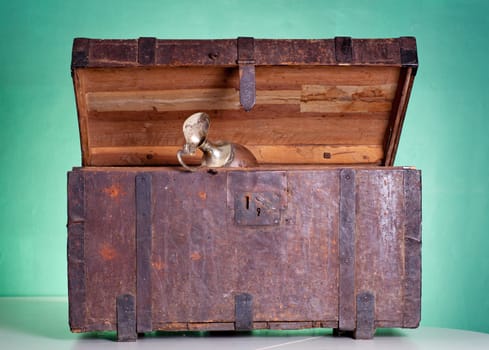 Glass pitcher inside an antique wooden trunk
