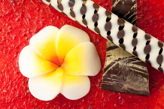Decoration with a chocolate tube over strawberry jelly.