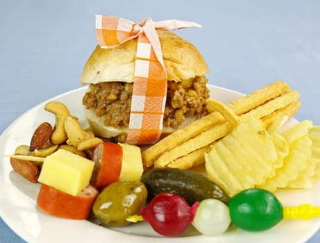 Mini slider beef burger with assorted finger food and nuts.