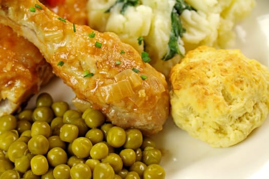 Delicious chicken drumstick with peas and a dumpling.