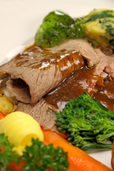 Delicious sliced roast lamb with baked vegetables and mint jelly.