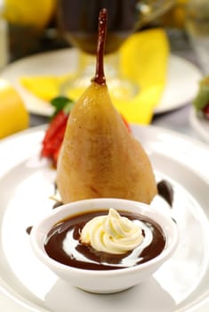 Delicious poached pear with chocolate syrup and cream.