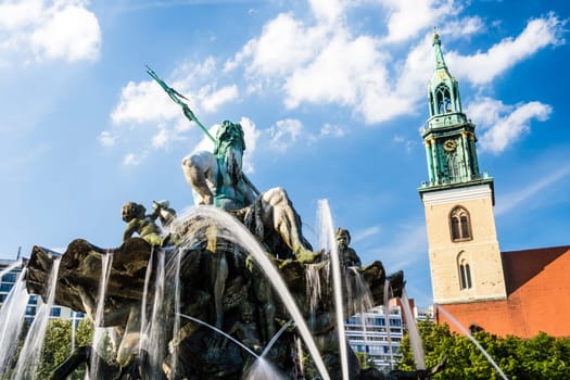 neptunbrunnen and marienkirche berlin on a sunny day