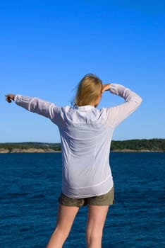 a young woman at the sea showing something