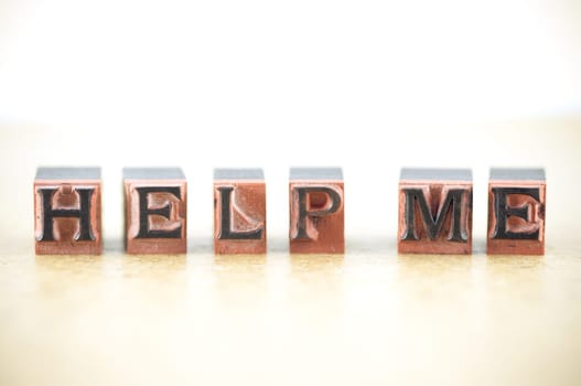 "help me"" spelled out in letterpress letters."