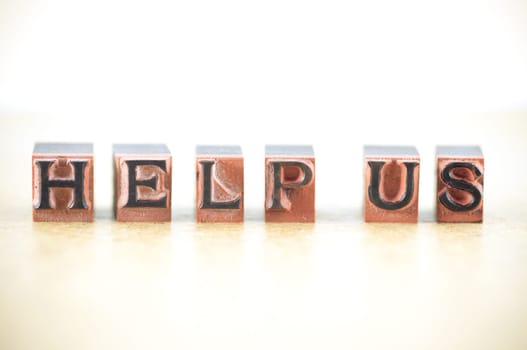 "help us"" spelled out in letterpress letters."